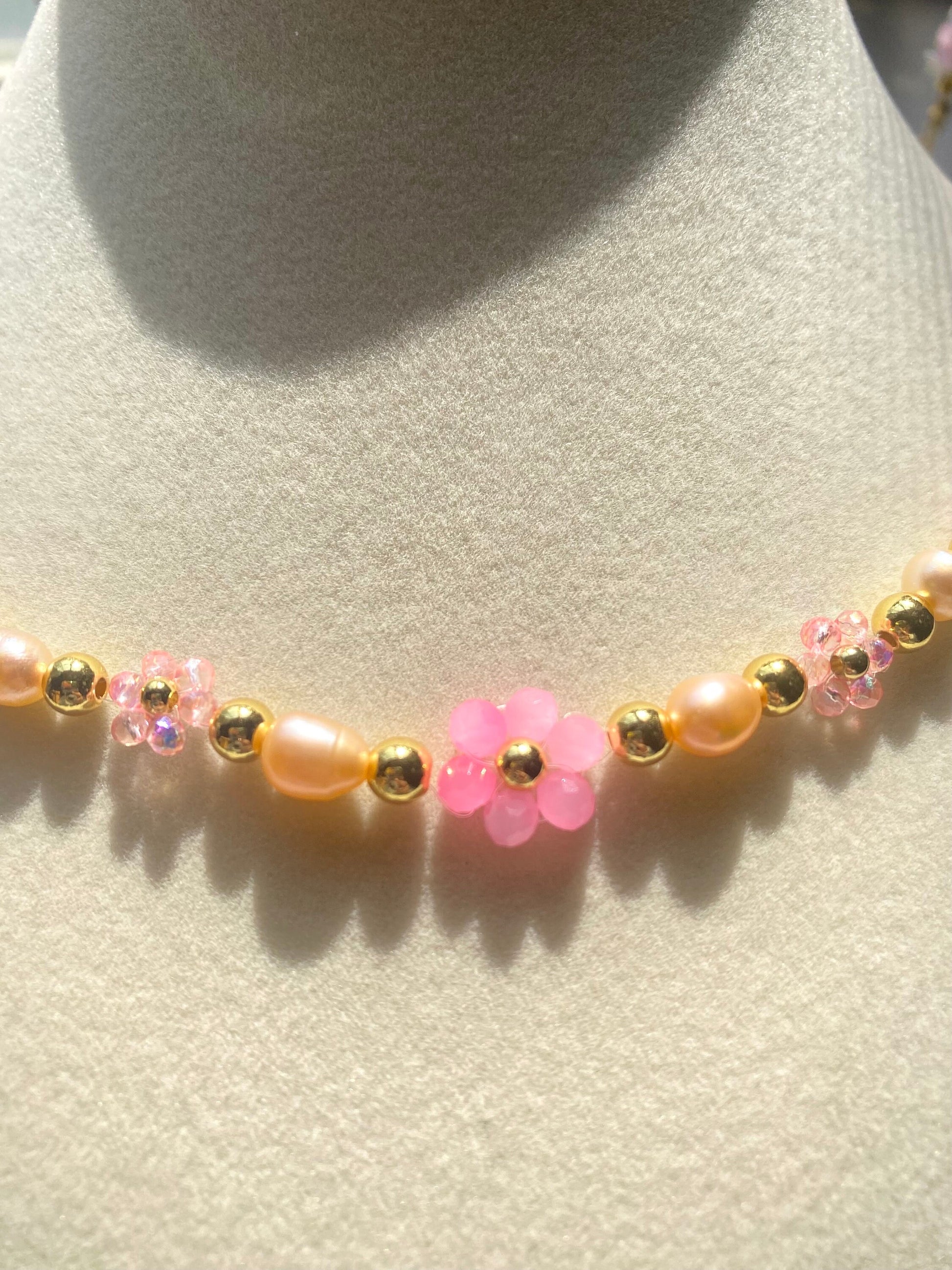 Handmade Pretty pink flower crystal beaded necklace with pink/orange freshwater pearls and 18k gold beads with a tarnish resistant gold brass chain. Crystal flowers in different sizes and different shades of pink. Perfect gift for any occasion!