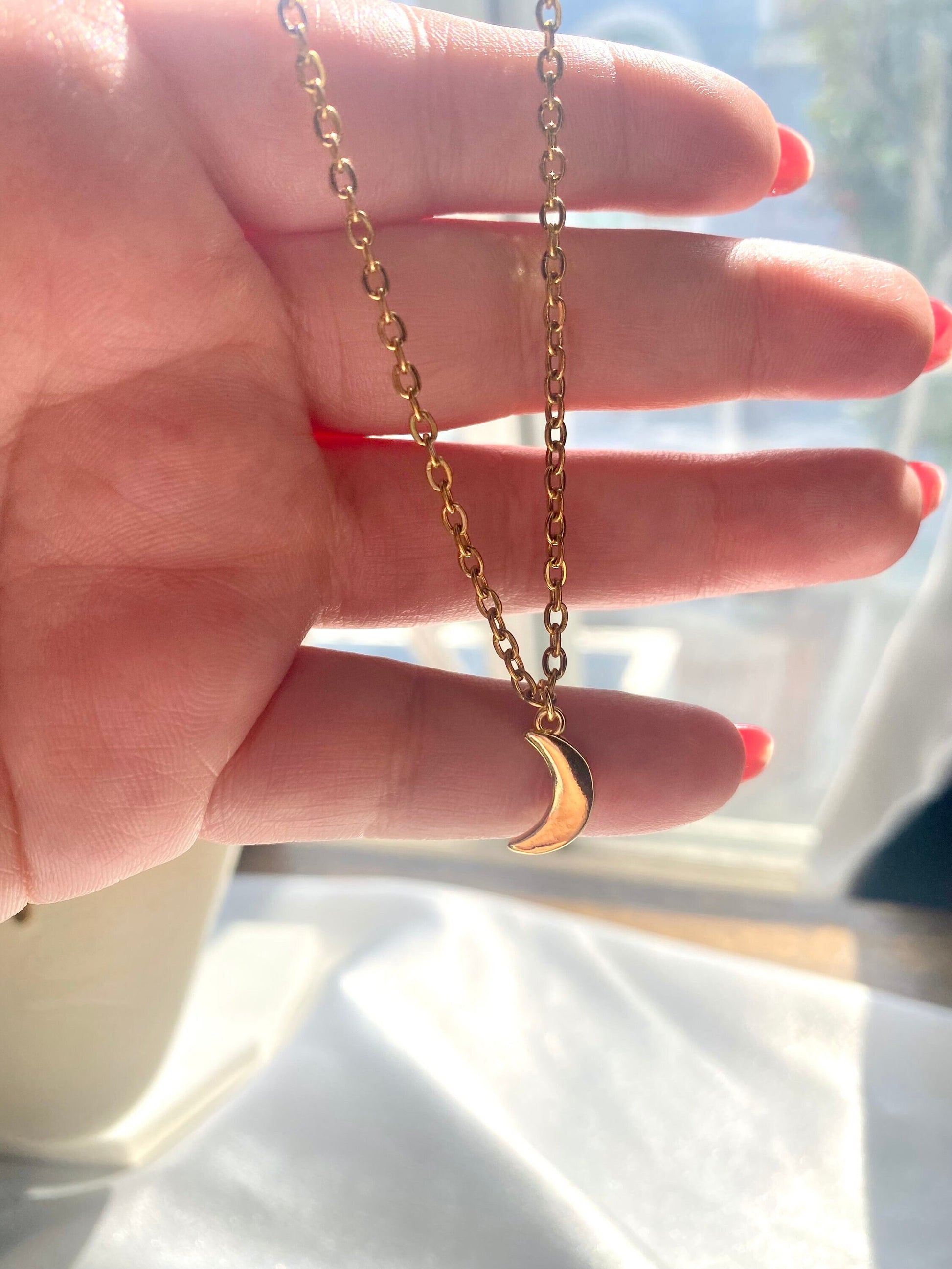 Showing an 18k Gold plated crescent moon pendant necklace perfect gift for any friend or special person in your life. Perfect gift for a birthday or christmas or any holiday!